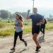 A group of runners enjoys a vibrant morning jog on a rural dirt road.